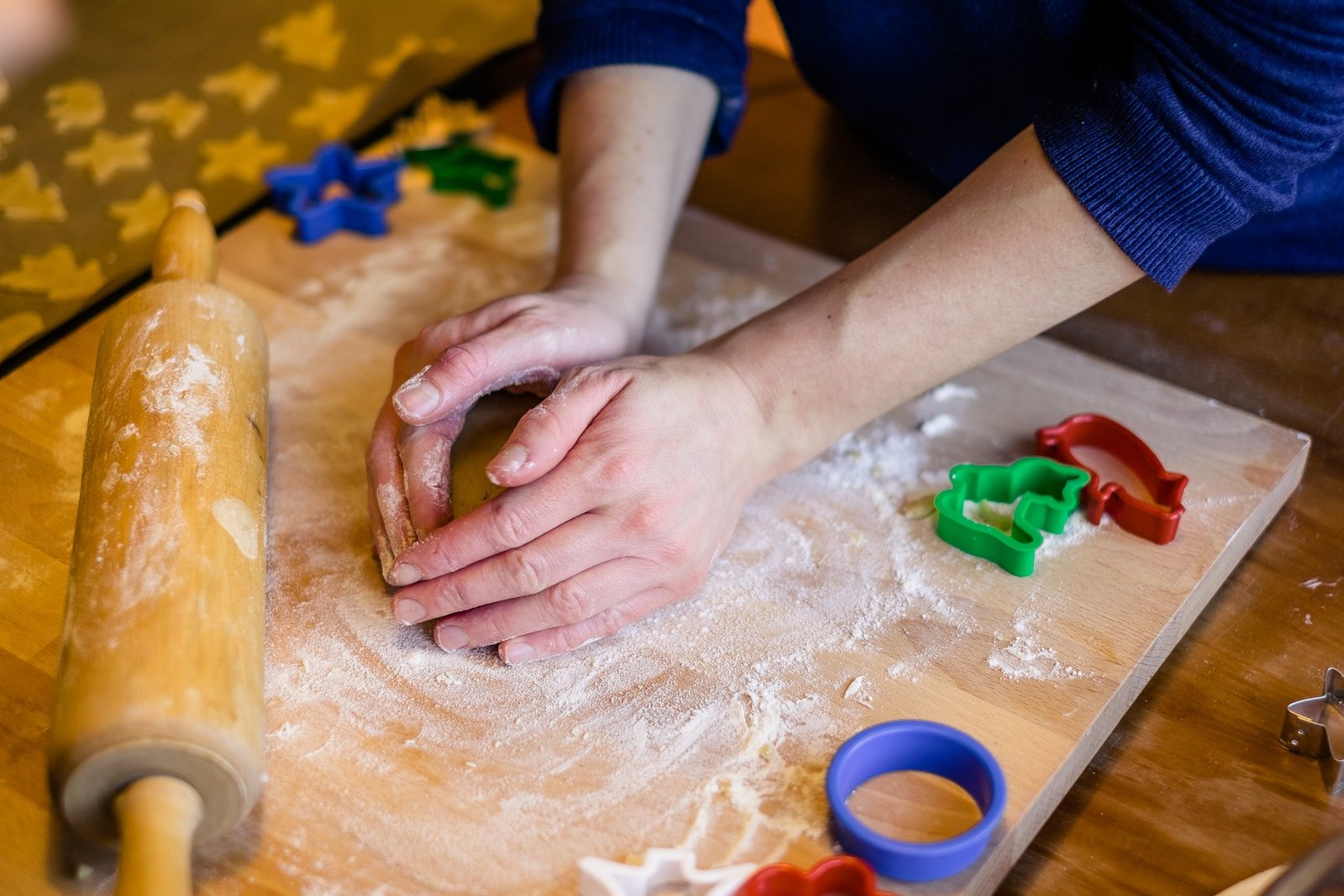 Caucasian person's hands kneading cookie dough